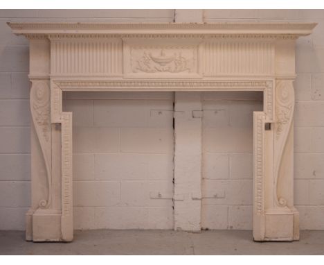 A large Georgian cream-painted mantelpiece with reeded and gadrooned decoration, the central panel carved with lamp and acant