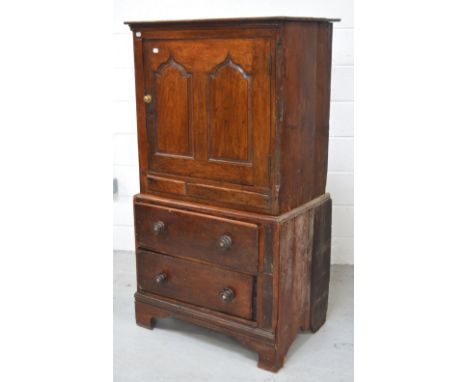 An antique oak cupboard, the upper section with arched panel door above two drawers on bracket feet, width approx 80cm, heigh