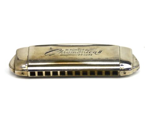 A vintage cased M Hohner harmonica.