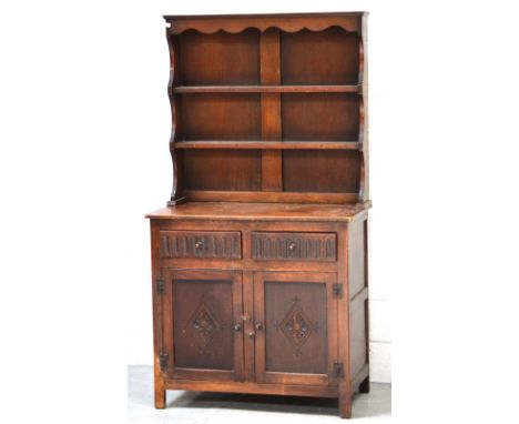 A carved oak Welsh dresser, two-shelf panel plate rack, two short drawers over two cupboard doors, 91 x 170cm.