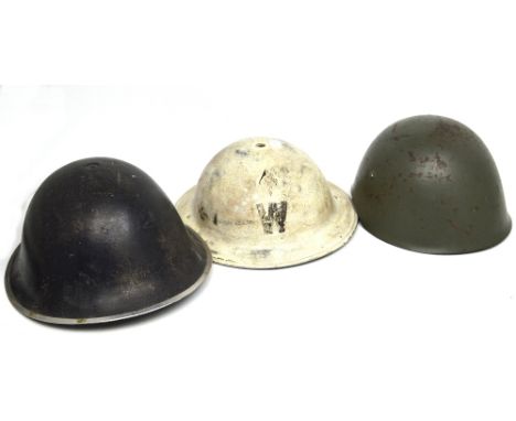 A post-war German helmet with liner, together with an American Army-issue helmet and a WWII period Air Raid Warden's helmet i