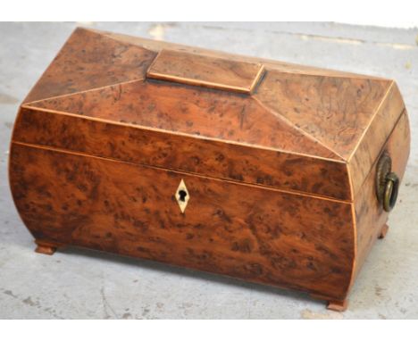 A mid-19th century burr walnut and satinwood sarcophagus-shaped tea caddy with brass ring handles, the interior with two fitt