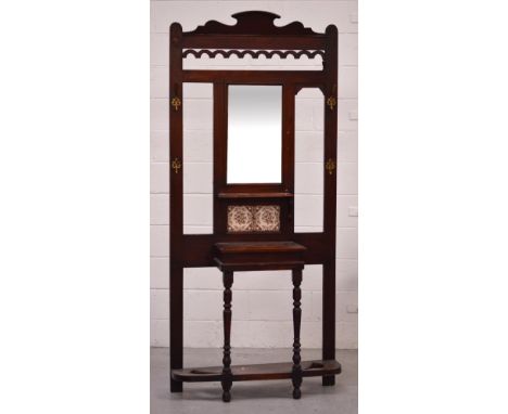 An Edwardian mahogany hall stand with brass coat hooks, central rectangular mirror above small shelf and two tiles, height 20