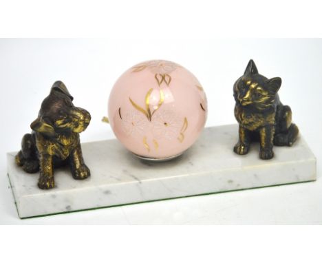 An Art Deco table lamp, central spherical pink shade with white and gilded floral decoration, metal dog and cat to either sid