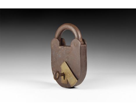 Late 19th century AD. A substantial iron padlock with brass sliding cover stamped with the King's Broad Arrow, 'I', royal arm