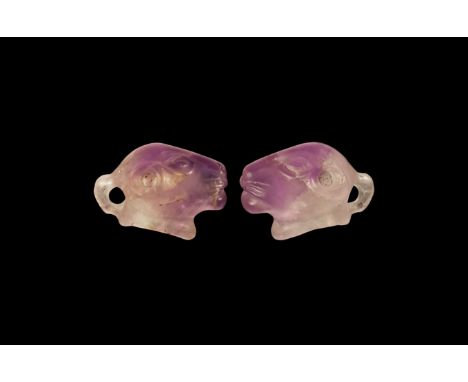 An undated archaistic carved amethyst pendant of a lion's head with almond-shaped eyes and incised whiskers to the muzzle; ho