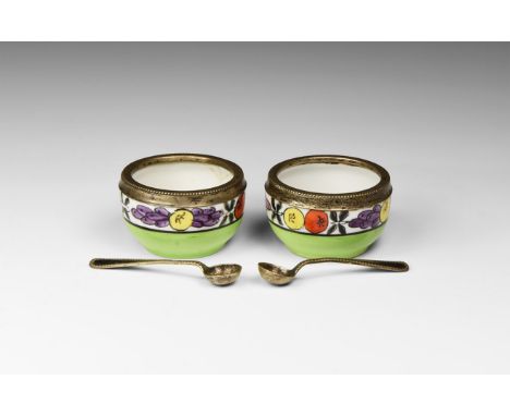Early 20th century AD. A matched pair of white-glazed ceramic salt containers, each with polychrome band of fruit to the shou
