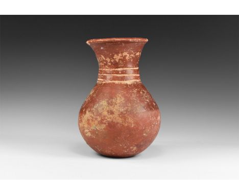 16th-17th century AD. A ceramic red ware vessel with flared rim and tapering neck with incised lines to the collar; globular 