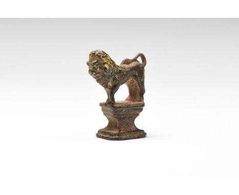 An undated archaistic bronze statuette of lion standing with tail recurved to the rump, rectangular waisted pedestal base. Cf