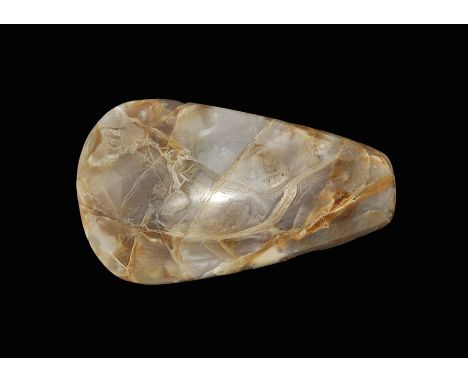 7th-4th century BC. A polished trapezoidal votive axehead in agate, the blade chamfered to both faces, the butt rounded. Cf. 