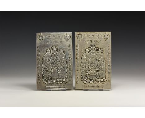 A pair of undated archaistic silver coloured metal plaques with four Taoist deities in courtly robes and headdresses holding 