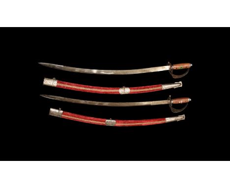 20th century AD. A pair of cavalry hangers, each with slightly curved single-edged blade, wooden grip, openwork guard, velvet