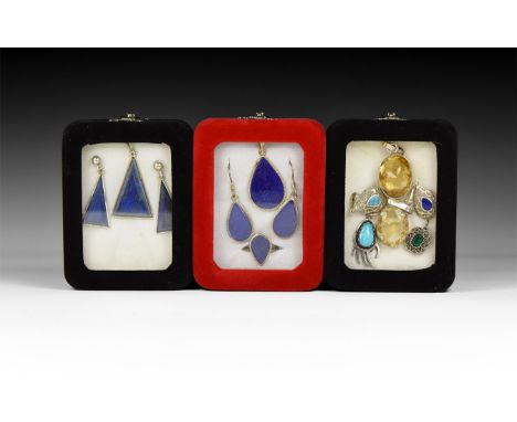 20th century AD. A group of three jewellery sets in silver-coloured metal with lapis lazuli inserts, each in a display box.  