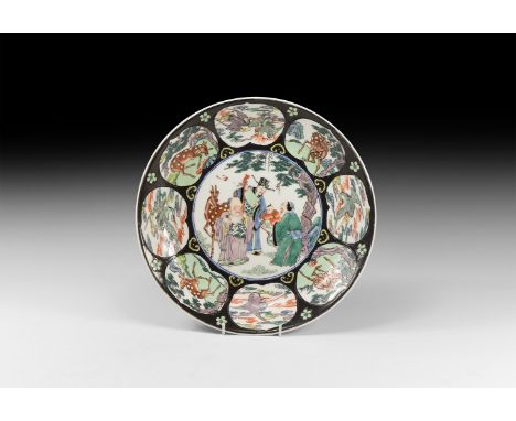 20th century AD. A white-glazed ceramic dish with enamelled decoration including vignettes of deer and birds surrounding the 