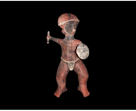 20th century AD. A large hollow-formed ceramic statue of a warrior with round shield in his extended left hand, fusiform ston