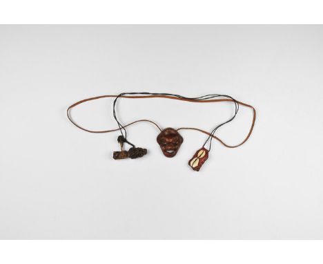 20th century AD. A mixed group comprising: a leather pouch on a thong with attached cowrie shells; a wooden waisted pendant w