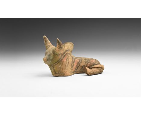 2nd millennium BC or later. An hollow-formed ceramic figure of a recumbent zebu with head raised and back legs curled; panels