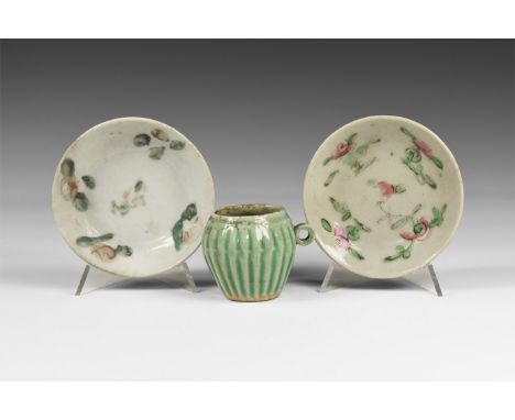 Ming Dynasty, 1368-1644 AD. A mixed group of glazed ceramic ware comprising a ribbed jar and two saucers with floral detailin