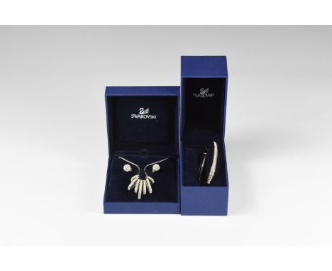 20th century AD. A matched jewellery suite set with Swarovski crystals comprising hinged silver-coloured metal bangle, a neck