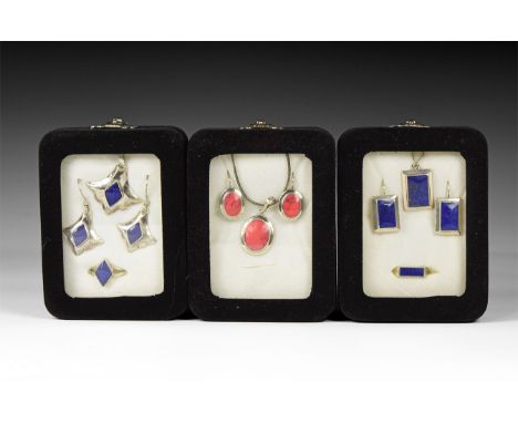 20th century AD. A group of three jewellery sets in silver-coloured metal with lapis lazuli and other inserts, each in a disp