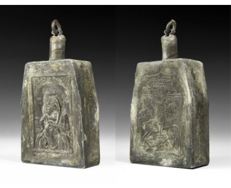 19th century AD. A large pewter flask with rectangular body, tubular neck and lid with attachment ring; to one side a low-rel