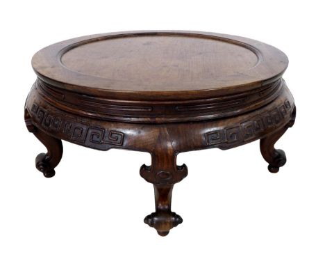 A Chinese circular hardwood opium table, with a relief decorated frieze on four scroll feet, 77cm diameter by 37cm high.