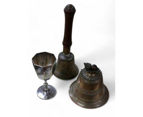 A brass temple bell, probably Tibetan or Burmese, with flowerhead petal top detail and animal finial a/f, with plaited rope, 