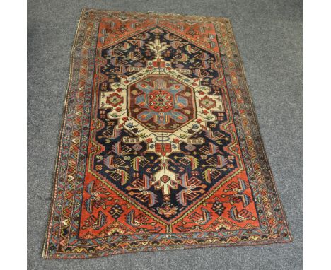 A Persian silk carpet in tones of red and blue, 170 cm x 106 cm