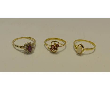 A ruby and diamond cluster ring, oval pink/red ruby, surrounded buy a band of round brilliant cut diamonds , total diamond we