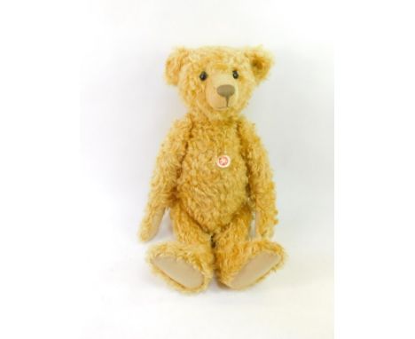 A Steiff plush jointed teddy bear, with button to ear and label to body, 58cm high.