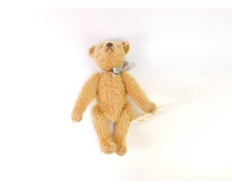 A Steiff plush jointed teddy bear, 2005, in light brown, with label to the ear and bow, 29cm high.