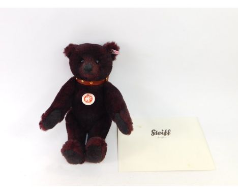 A Steiff limited edition teddy bear, in dark red, number 881/2009, with growl action and brown leather finish collar, with la