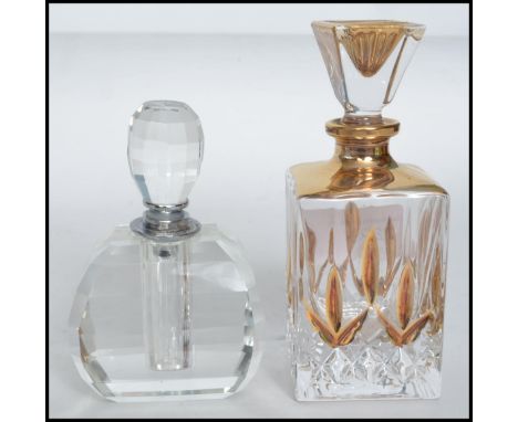 Two vintage 20th century art deco cut glass perfume bottles of faceted form with stoppers atop. Measures: 13cm high. 