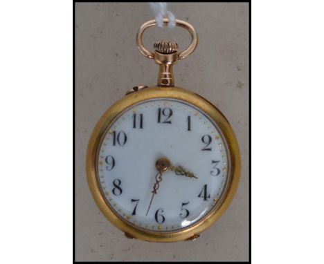 A vintage 18ct gold miniature pocket watch having a crown winder t top with open enamel face having Arabic numerals and gilt 