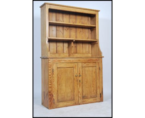 A 19th century Victorian country pine Welsh Dresser having  twin cupboard doors to the dresser base with a series of fixed sh