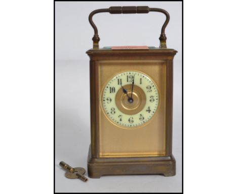 An early 20th century brass carriage clock, possibly French having an enamel face with Arabic chapter ring housed within a br