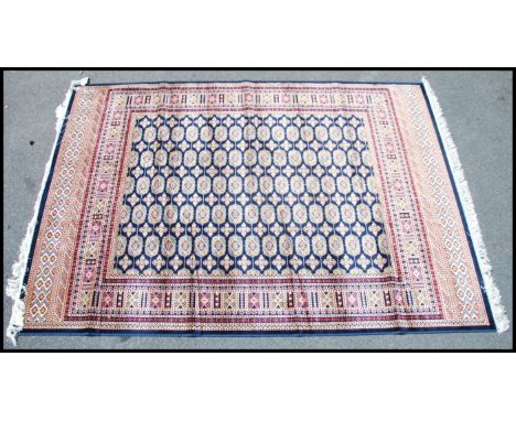 A large Iranian / Persian Bokhara carpet - rug having red ground with geometric decoration and borders. Measures 2.30 x 1.60 