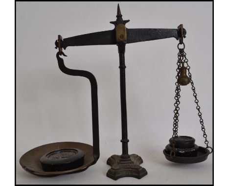 A pair of 19th century 4lb grocers cast metal balance scales fitted with a brass pan with weights. Measures 44cms high.