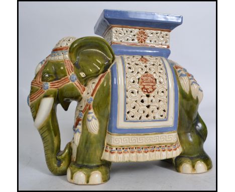 A large elephant ceramic plant stand in green white and blue with plinth top dating to the 20th century