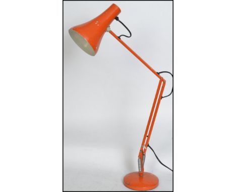 A vintage 20th century retro industrial anglepoise desk lamp in original orange paint raised on circular base with pendant sh