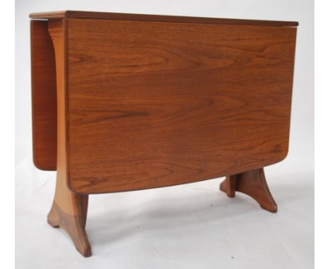 A 1970's teak wood Danish influenced G-Plan drop leaf dining table raised on shaped supports with full length drop leaves hav