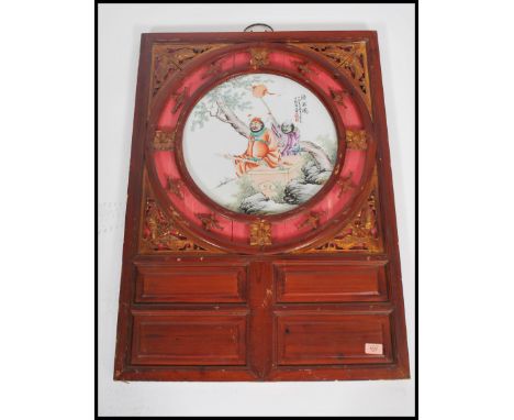 A 20th century Chinese ceramic circular plaque decorated in enamels with garden figural scene and with character writing with