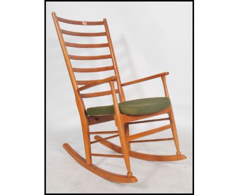 A 1960's Danish inspired teak ladder back rocking chair in the manner of Scandart having a green upholstered seat 