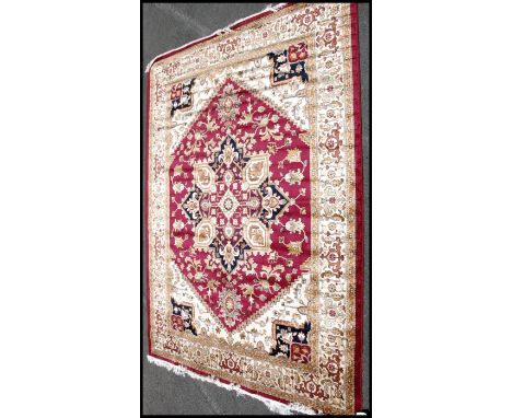 A large North Western Iranian / Persian Heriz carpet - rug having red and beige ground with geometric decoration and borders.