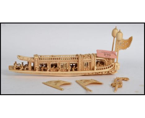 A 19th century Chinese carved ivory junk decorated with numerous figures (some damages and losses). Measures:  20cm long.