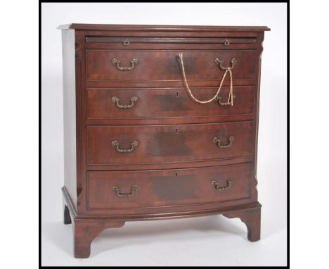 A Mahogany Georgian style bow front bachelors chest of drawers having four long drawers chest with drop handles raised on bra