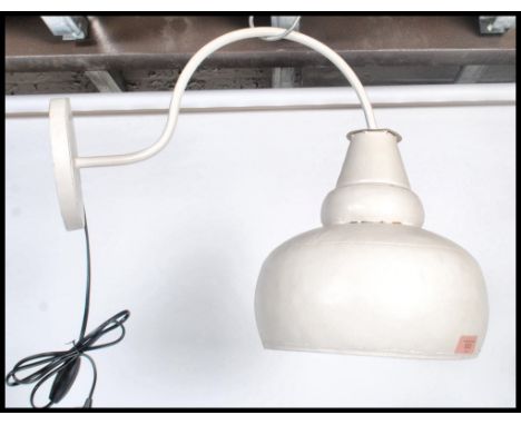 A vintage retro industrial style outdoor factory type yard light having a tubular scroll arm attached to an over sized bulbou