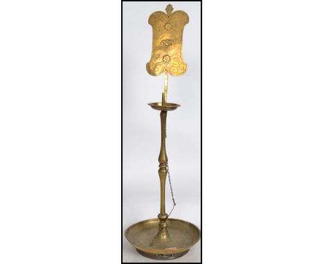 A vintage 19th century Oriental temple large pricker brass candlestick having a lozenge back panel with symbols of luck raise