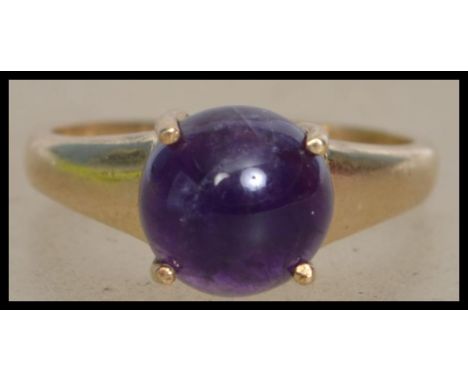 A Hallmarked 9ct gold ring set with a amethyst cabochon. Hallmarked for Birmingham. Size P. Total weight 3.8g.