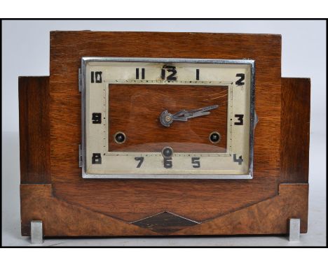 A 1920s Art Deco mantel clock with square face having an Arabic numeral dial enclosing three train movement raised on square 